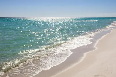 a sandy beach with the ocean in the background at Tidewater Escape: 1BR/2BA beachfront condo, sleeps 6, Gulf views & comfort! in Panama City Beach