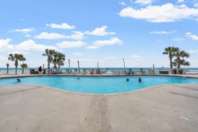 a swimming pool at the beach with people in it at Watercrest Waves! Beachfront 2BR/2BA condo, Sleeps 8, Stunning Gulf Views! in Panama City Beach