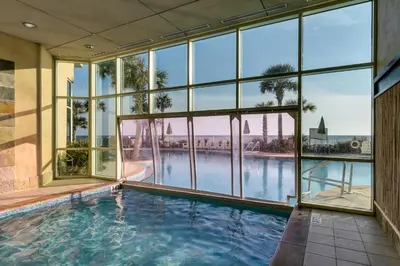 an indoor swimming pool in a building with large windows at Aqua 1905 in Panama City Beach