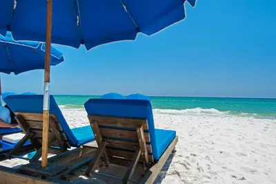 two chairs and an umbrella on a beach at Aqua 0208 in Panama City Beach