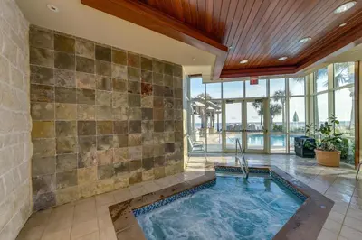 an indoor swimming pool in a room with a stone wall at Aqua 1501 in Panama City Beach