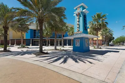 a blue sign in front of a building with palm trees at Treasure Island Unit 2011: Sunset Sands, 2 Bed/2 Bath Retreat – Sleeps 8! in Panama City Beach