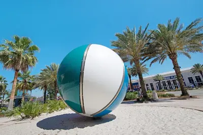 a large surfboard sculpture in a park with palm trees at Treasure Island Unit 2011: Sunset Sands, 2 Bed/2 Bath Retreat – Sleeps 8! in Panama City Beach