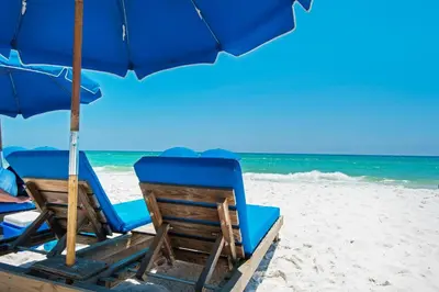 two chairs and an umbrella on a beach at Tidewater 715 in Panama City Beach
