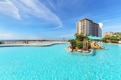 a resort with blue water and a tall building at Edgewater Golf Villa 3204 in Panama City Beach