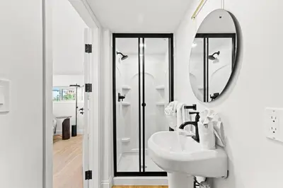 a white bathroom with a sink and a mirror at Ocean Breeze 1C in Panama City Beach