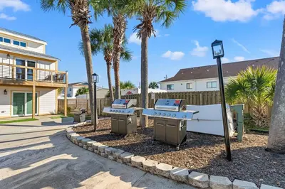 a street with two picnic tables and palm trees at Ocean Breeze 1C in Panama City Beach