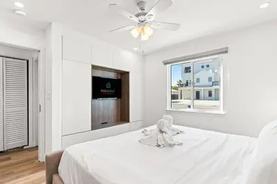 a white bedroom with a stuffed animal sitting on a bed at Ocean Breeze 2A in Panama City Beach