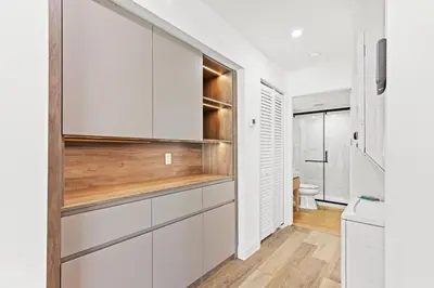 a kitchen with white cabinets and a toilet at Ocean Breeze 2A in Panama City Beach