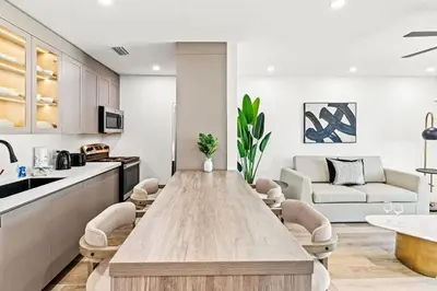 a kitchen and living room with a large wooden table at Ocean Breeze 2B in Panama City Beach