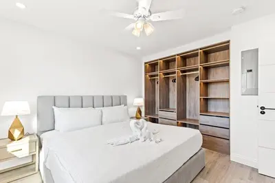 a bedroom with a white bed with a dog on it at Ocean Breeze 2D in Panama City Beach