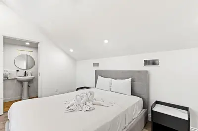 a white bedroom with a large bed with a mirror at Ocean Breeze 3C in Panama City Beach
