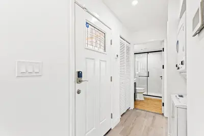 a white hallway with a door and a toilet at Ocean Breeze 3C in Panama City Beach