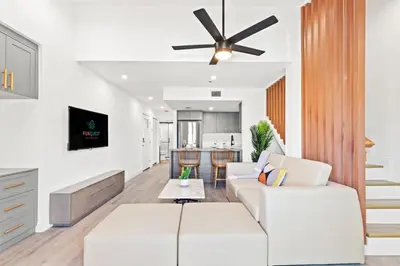 a living room with white furniture and a ceiling fan at Ocean Breeze 3D in Panama City Beach