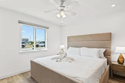 a bedroom with a bed with a ceiling fan and a window at Ocean Breeze 3B in Panama City Beach