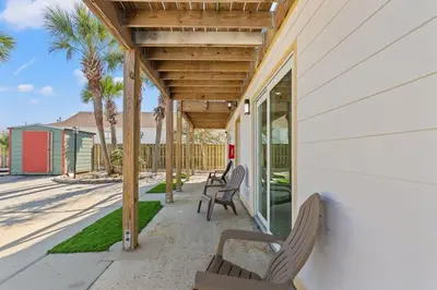 a porch with chairs and a wooden pergola at Ocean Breeze 3B in Panama City Beach