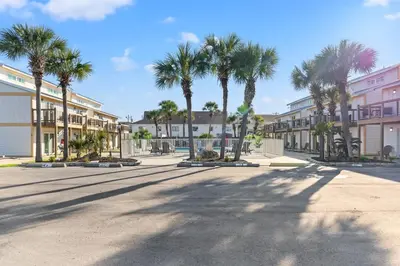 a city street with palm trees and buildings at Ocean Breeze 3B in Panama City Beach