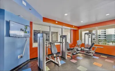 a gym with two treadmills and two ellipticals at Spacious 2-Bedroom Condo Beachfront Resort! By Dolce Vita Getaways PCB! in Panama City Beach