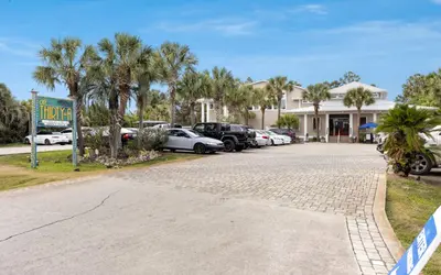 a parking lot with cars parked in front of a building at Our Tree House by Oversee 30A in Inlet Beach