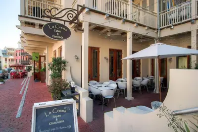 a restaurant with tables and an umbrella on a street at Cassine Way 303 - Seagrove + Sunsets in Santa Rosa Beach