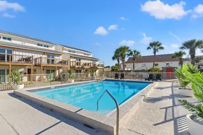 a swimming pool in a resort with palm trees at Ocean Breeze 5A in Panama City Beach