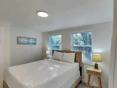 a bedroom with a large bed and two windows at Salt & Sea C in Panama City Beach
