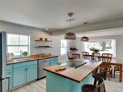 a kitchen with blue cabinets and a wooden table at Salt & Sea C in Panama City Beach