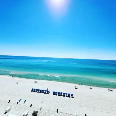 a view of a beach with chairs and the ocean at Nothin But Time by Beach Haven Vacation Rentals in Panama City Beach