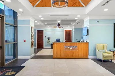 an office lobby with a reception desk and a chair at Origin 0517 - One Bedroom - Partial Gulf View by Beach Haven Vacation Rentals in Panama City Beach