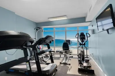 a room with a gym with a view of the ocean at Emerald Isle 403 by Emerald Coast Retreats in Panama City Beach