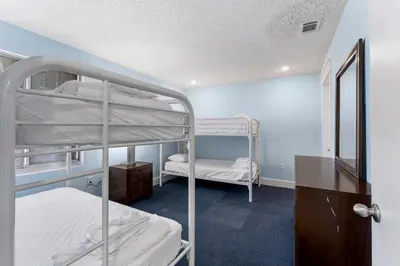 a room with two bunk beds in it at Sharkys Retreat 701 by Beach Haven Vacation Rentals in Panama City Beach