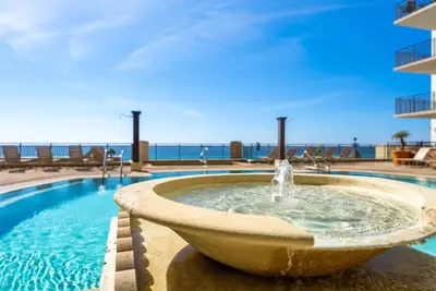 a fountain in a pool with the ocean in the background at Origin 1605 - Two Bedroom - Partial Gulf View by Beach Haven Vacation Rentals in Panama City Beach