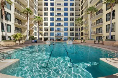 a swimming pool in front of a large apartment building at Origin 0808 - One Bedroom - Sunny Pool Deck & Gulf Views! by Beach Haven Vacation Rentals in Panama City Beach