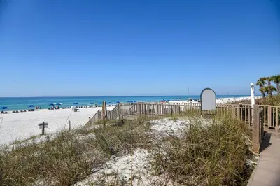 a sandy beach with a fence and the ocean at Boardwalk Beach Resort #1107 by Book That Condo in Panama City Beach