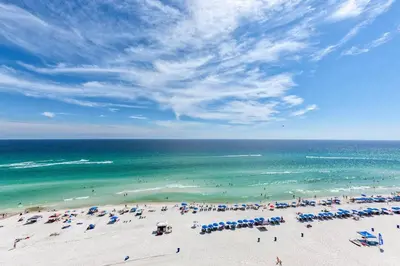 a beach with a lot of umbrellas and the ocean at Edgewater Tower 1-608 in Panama City Beach