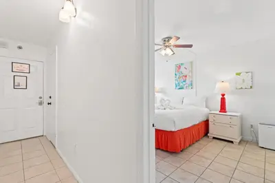 a white bedroom with a bed and a ceiling fan at The Summit 1009 in Panama City Beach