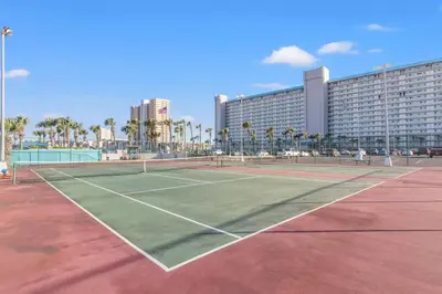 a tennis court in front of a large building at The Summit 1009 in Panama City Beach