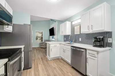 a kitchen with white cabinets and stainless steel appliances at Blue & Red Neptune by Nautical Properties Vacation Rentals in Panama City Beach