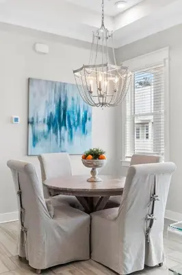 a dining room table with chairs and a chandelier at Isle be Back in Inlet Beach