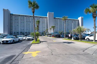 a parking lot with cars parked in front of a large building at Once Upon A Dream - Beachfront Bliss in Panama City Beach