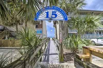 a clock on the side of a building with palm trees at Steps to the Beach PCB Condo with Balcony! in Panama City Beach