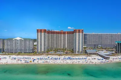 a group of people on a beach in front of a hotel at Shores of Panama Beachfront 2nd Floor Unit 208! No elevators needed! in Panama City Beach