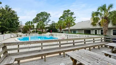 a deck with benches and a swimming pool at Beachwood Villas 1C in Santa Rosa Beach