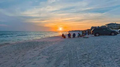 a group of people on a beach at sunset at Beachwood Villas 1C in Santa Rosa Beach