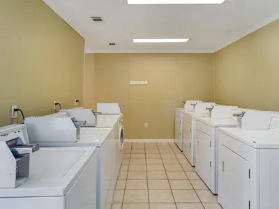 a row of white washing machines in a room at Sunny Daze at Beachwood Villas - Walk to Beach Outdoor Pools & More in Santa Rosa Beach