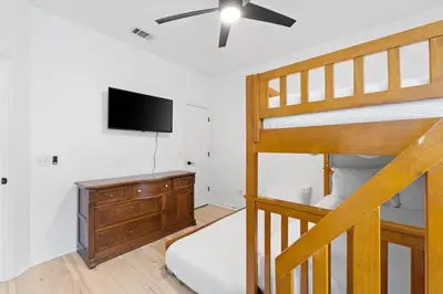 a bedroom with a bunk bed and a television at Pet Friendly Beach House - Baby Blue Heron by Panhandle Getaways in Panama City Beach