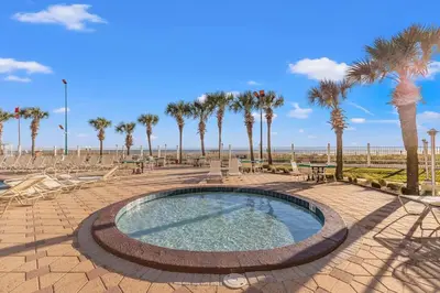 a swimming pool with palm trees and the beach at The Summit 315 in Panama City Beach