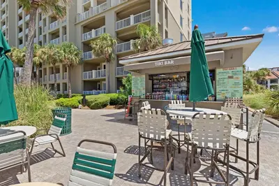 an outdoor patio with tables and chairs and umbrellas at Grand Panama Beach Resort by Panhandle Getaways in Panama City Beach