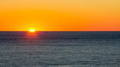 an orange and yellow sunset over the ocean at It Doesn’t Get Any Better Than This! 2BR 2BA Sleeps 8 Beachfront! in Panama City Beach