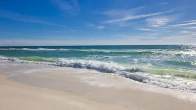a beach with the ocean and the waves at It Doesn’t Get Any Better Than This! 2BR 2BA Sleeps 8 Beachfront! in Panama City Beach